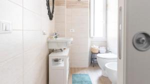 La salle de bains blanche est pourvue d'un lavabo et de toilettes. dans l'établissement Casa Otto, à Rome