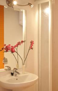 a bathroom with a sink with a vase with flowers in it at MH Apartments Liceo in Barcelona