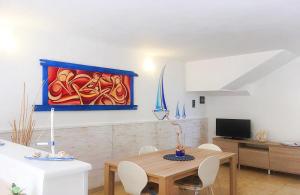 un soggiorno con tavolo e un dipinto sul muro di Leuca Casa del Mare in centro a Leuca