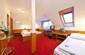 a hotel room with two beds and a desk at Hotel Primus Frankfurt Sachsenhausen in Frankfurt