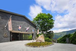 a building with flags and a rock in front of it at THE HIRAMATSU HOTELS & RESORTS SENGOKUHARA HAKONE in Hakone