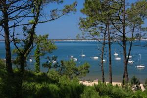 a view of a beach with boats in the water at Thalazur Arcachon in Arcachon