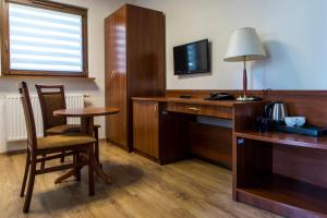 a hotel room with a desk and a table and chair at Hotel Camping Malta in Poznań