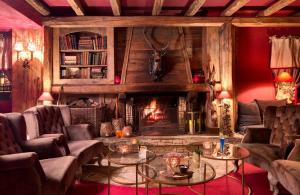 
a living room filled with furniture and a fire place at Hotel Au Chamois d'Or in L'Alpe-d'Huez

