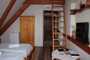 a bedroom with two bunk beds and a ladder at Edvy Malom Fogadó Barokk Udvarház in Pápa