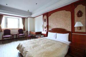 Habitación de hotel con cama, mesa y sillas en Hua Du Hotel, en Keelung