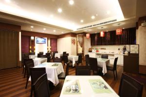 een restaurant met witte tafels en stoelen en een bar bij Hua Du Hotel in Keelung