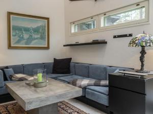 een woonkamer met een blauwe bank en een tafel bij Holiday Home Atelje 4 by Interhome in Tahkovuori