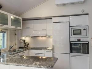 ターコブオリにあるHoliday Home Atelje 4 by Interhomeの白いキッチン(白いキャビネット、電化製品付)