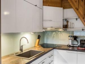 een keuken met witte kasten en een spoelbak bij Holiday Home Aaria by Interhome in Tahkovuori