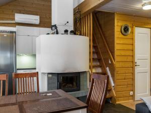 een keuken met een open haard en een tafel en stoelen bij Holiday Home Aaria by Interhome in Tahkovuori