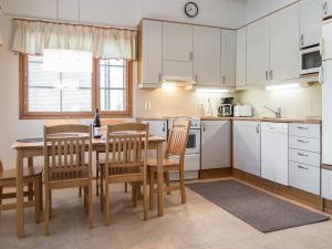 a kitchen with white cabinets and a table and chairs at Holiday Home Aida by Interhome in Tahkovuori