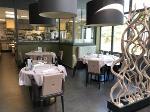 a restaurant with tables and chairs in a room at La table d’Auguste in Dour