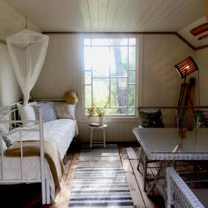 een woonkamer met een bed en een raam bij Pähkli Seaside Cottage with Cozy Outdoor Patio in Kõiguste
