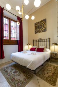 1 dormitorio con 1 cama grande y cortinas rojas en Teatro Suites Málaga, en Málaga