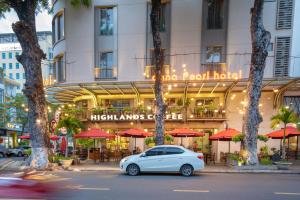 un coche blanco estacionado frente a un hotel en Dana Pearl Hotel, en Da Nang