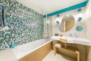 a bathroom with a tub and a sink and a shower at Center Parcs Le Bois aux Daims in Morton