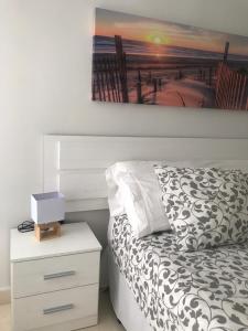 ein Schlafzimmer mit einem Bett, einem Nachttisch und einem Gemälde in der Unterkunft Habitación en Casa Qerétaro in Silla