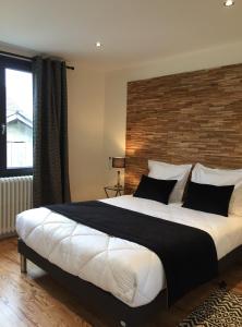 a bedroom with a large bed with a brick wall at LA PORTE DES ALPES in Barberaz