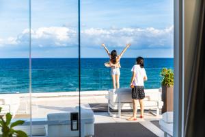 two girls looking out of a window at the ocean at Victoria Palace Cefalù in Cefalù