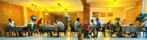 a group of people sitting at tables in a restaurant at Yucesan Hotel in Avsallar