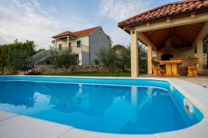 een zwembad voor een huis bij Villa Ane, Divine holiday in Trbounje