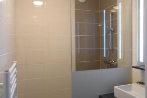 una ducha con puerta de cristal en un baño en Résidence Le 101, en Millau