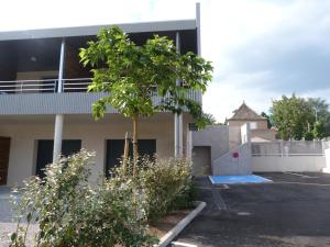 un edificio con un árbol en un estacionamiento en Résidence Le 101, en Millau