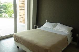 Un dormitorio con una cama grande con una ventana grande. en Résidence Le 101, en Millau