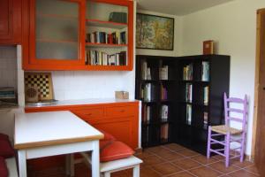 a kitchen with a table and chairs and book shelves at Fonda Domingo in Lles