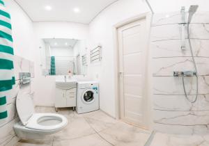 a bathroom with a toilet and a washing machine at Апартаменты на Ленина 43 in Voronezh