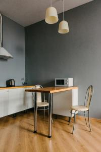 a kitchen with a table with two chairs and a microwave at Апартаменты на Ленина 43 in Voronezh