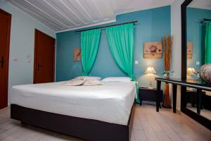 a bedroom with a large bed with blue walls at Elia Portou Rooms in Chania