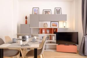 una sala da pranzo con tavolo e TV di Bologna House Tubertini Apartment a Bologna