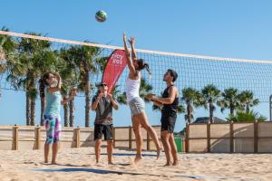 Playitas Aparthotel - Sports Resort في لاس بلايتاس: مجموعة من الناس يلعبون كرة الطائرة على الشاطئ