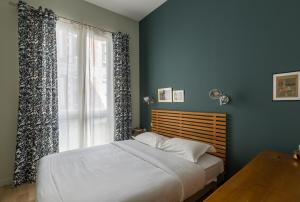 a bedroom with blue walls and a bed with a window at Veeve - The Library Wall in Paris