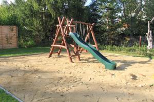 un parque infantil con un tobogán en la arena en Óhuta, en Parád