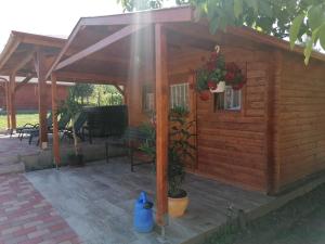 een houten hut met een veranda en een patio bij Ilona Prémium Vendégház - Kismaros in Kismaros
