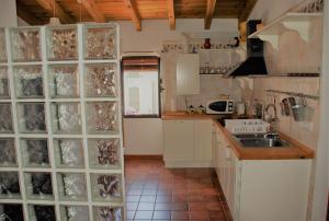 kuchnia ze szklanymi ścianami i zlewem w obiekcie Casa Rural La Torre w mieście Almonaster la Real