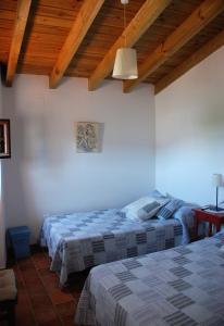 dwa łóżka w pokoju z drewnianym sufitem w obiekcie Casa Rural La Torre w mieście Almonaster la Real