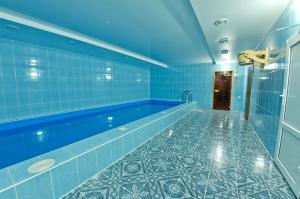 皮亞季戈爾斯克的住宿－Hotel Orlinye Skaly，浴室设有蓝色瓷砖的游泳池