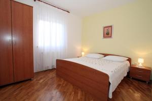 a bedroom with a bed with two pillows on it at Apartmani Radan in Pag