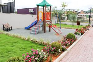 un parque infantil con un tobogán y algunas flores en Pousada Casarão Schmidt, en Pomerode