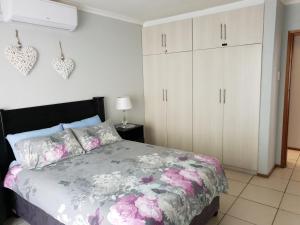 a bedroom with a bed and white cabinets at 11 Villa Del Sol in Amanzimtoti +34 photos