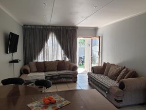 sala de estar con sofá y mesa en 11 Villa Del Sol, en Amanzimtoti
