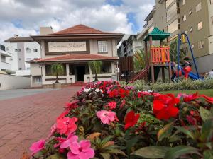 Pousada Casarão Schmidt في بوميرودي: حديقة من الزهور أمام المبنى