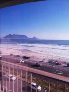 a view of a beach with cars parked on the road at 504 Witsand in Bloubergstrand