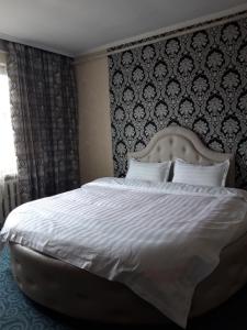 BULBUL JAMAK TRAVEL hostel في أولجي: غرفة نوم مع سرير أبيض كبير مع اللوح الأمامي