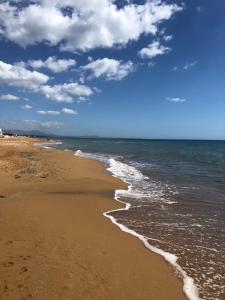 a sandy beach with the ocean and clouds in the sky at VILLA A 200 METRI DAL MARE in Castelvetrano Selinunte