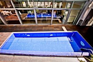 duży niebieski basen przed budynkiem w obiekcie Dal Moro Gallery Hotel w Asyżu